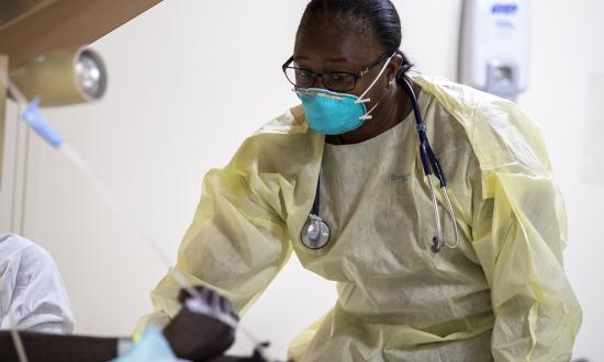 A Navy sailor treats a patient onboard the hospital ship Mercy.  