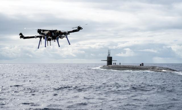 An unmanned aerial  vehicle approaches the USS Henry M. Jackson (SSBN-730) with a payload during a replenish­ment evaluation. The role of unmanned systems in the Navy must flow from larger questions about strategy and purpose.