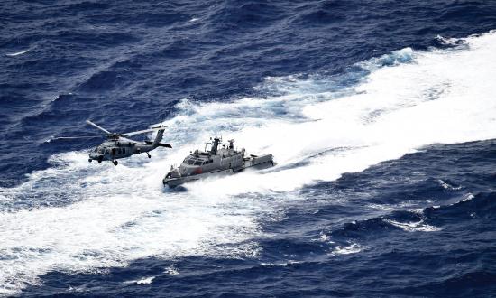 Aerial oblique view of a U.S. Navy Seahawk helicopter and a fast patrol boat