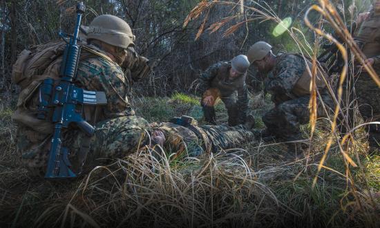 Navy corpsmen treat a simulated casualty in the field.